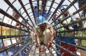 # 2006 A worker - who seems to have been caught in a web - puts final touches to a foundation piling for a bridge in Al Awir. # Image Credit: Devadasan/Gulf News