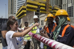 Dana El-Kalache and Ammar Al Alwan distribute water to workers on a construction site as part of the Sameness Project's campaign during the hot summer months. Antonie Robertson / The National