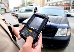 An official from the traffic department prepares to issue a fine to a parked car at Jamal Abdul Nasr street in Sharjah, April 1, 2009.  Photo by Chandra Balan