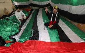 Ibrahim Mohammad Saeed (right) shows his 5.75km long UAE Flag at his shop in Mussafah Industrial area, Abu Dhabi, on Monday. (Photo by Ryan Lim)